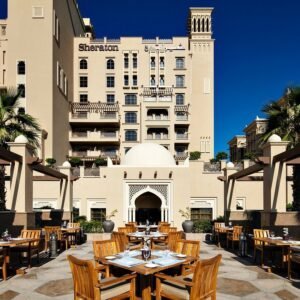 مطعم أرجوان يقدم تجربة طعام فاخرة في فناء خارجي أنيق مع ديكور حديث وإطلالة مميزة على فندق شيراتون.